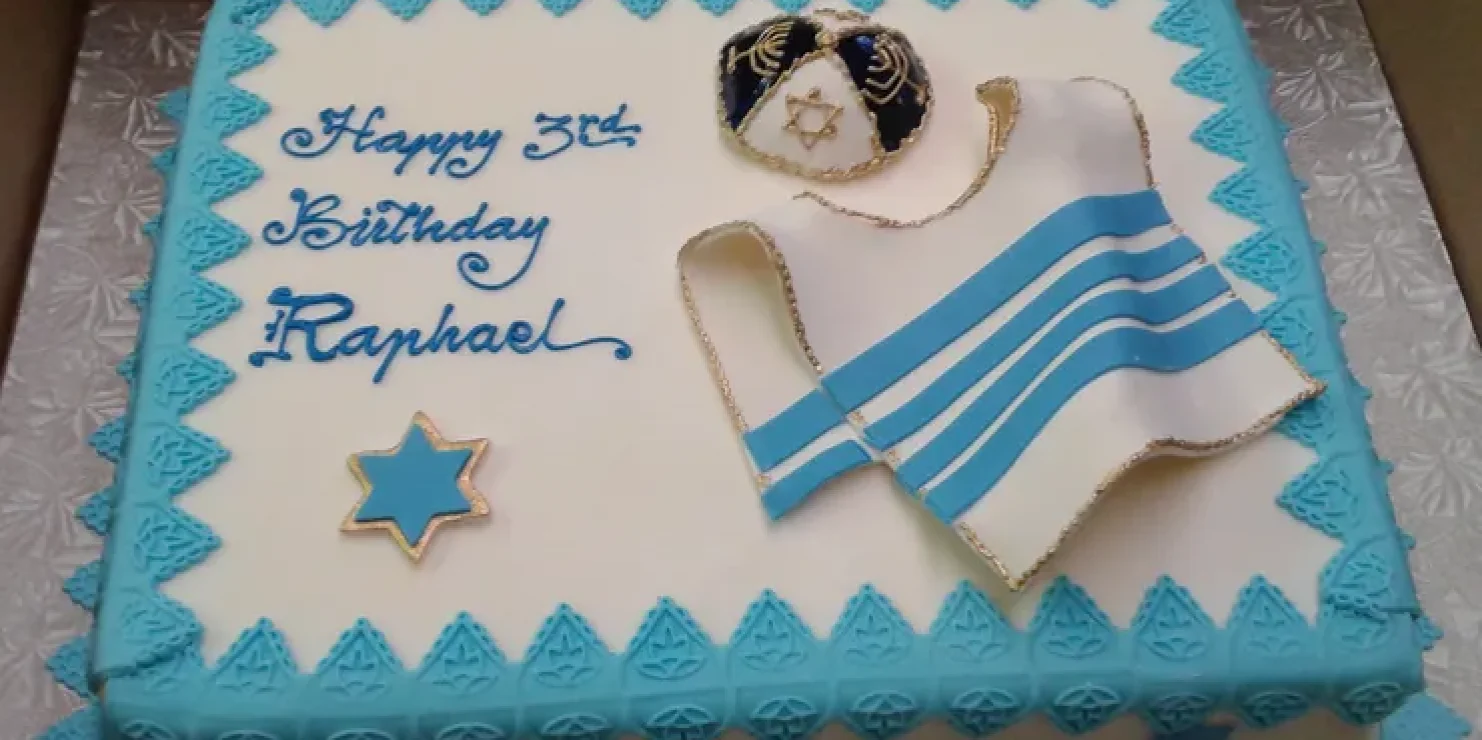 A kosher cake adorned in blue and white, featuring a symbol of Jewish significance. Richmond Kosher Bakery