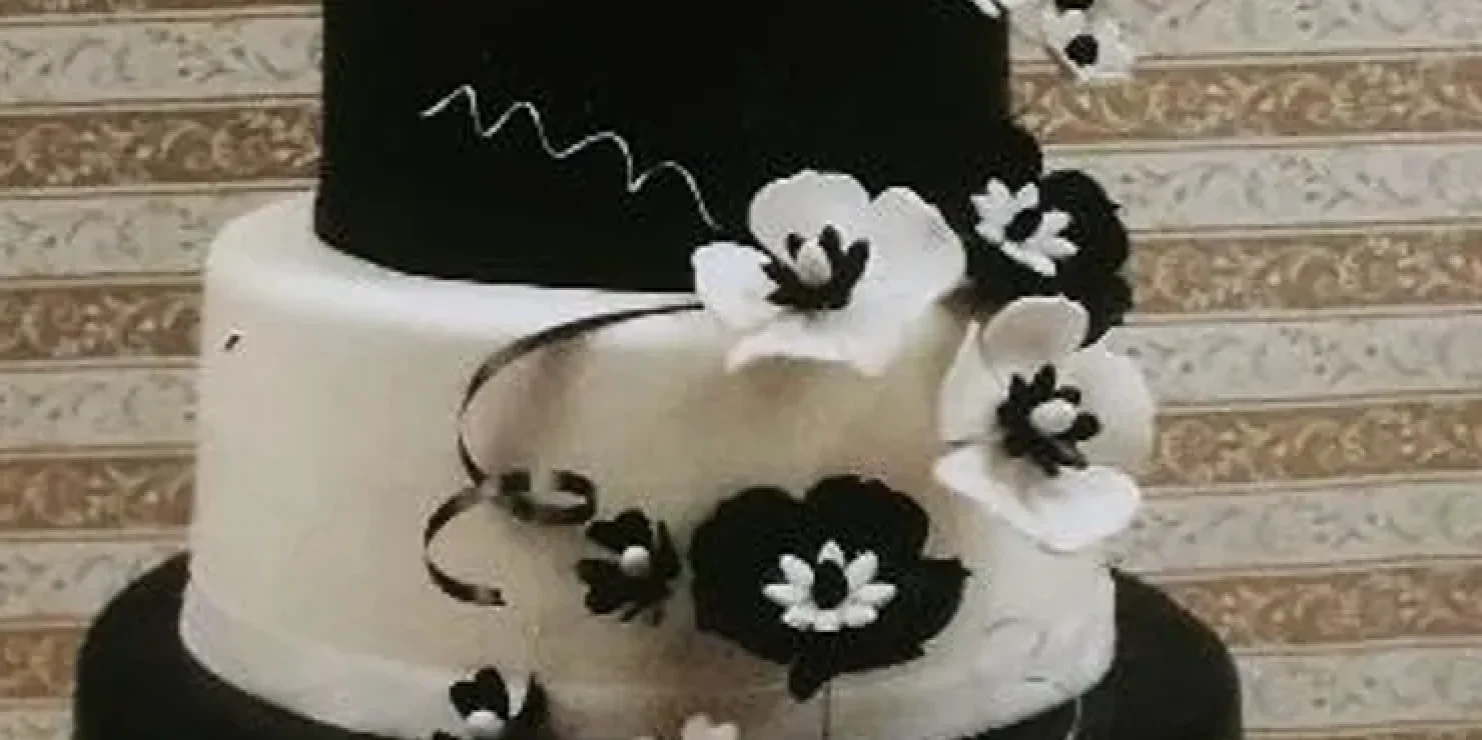 A Kosher black and white wedding cake displayed on a table. Richmond Kosher Bakery